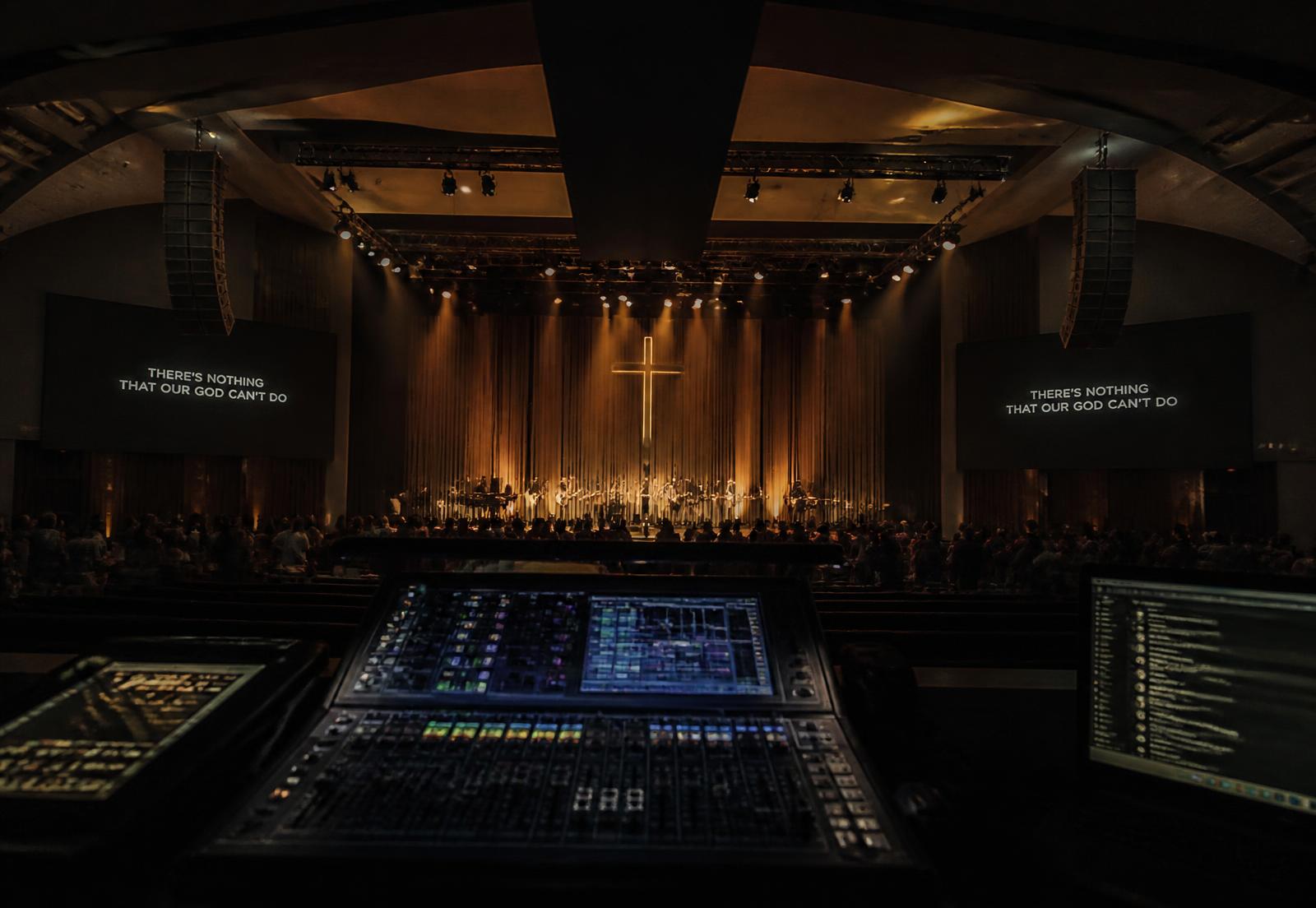 Church sanctuary with line array speakers, stage lighting and a digital mixing console